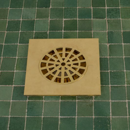Handmade Moroccan solid brass square shower drain cover with decorative geometric cutout pattern and polished brass finish.