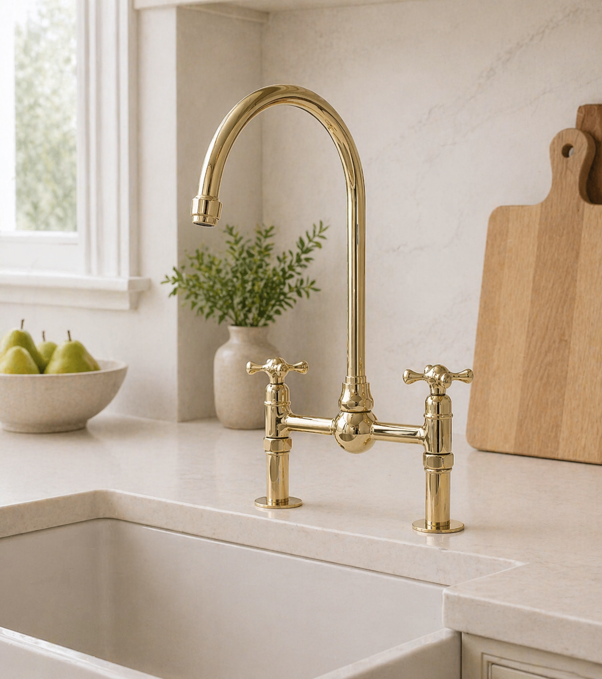 Unlacquered brass bridge kitchen faucet with high-arc spout and cross handles over a farmhouse sink