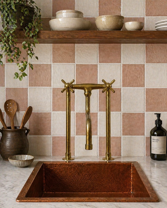 Tall unlacquered brass bridge kitchen faucet with long linear legs, cross handles and curved spout