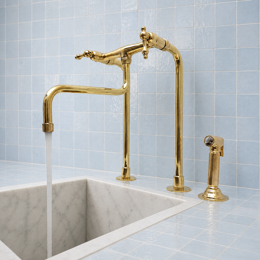 Tall unlacquered brass bridge kitchen faucet with lever handles, extended curved spout and handheld side sprayer